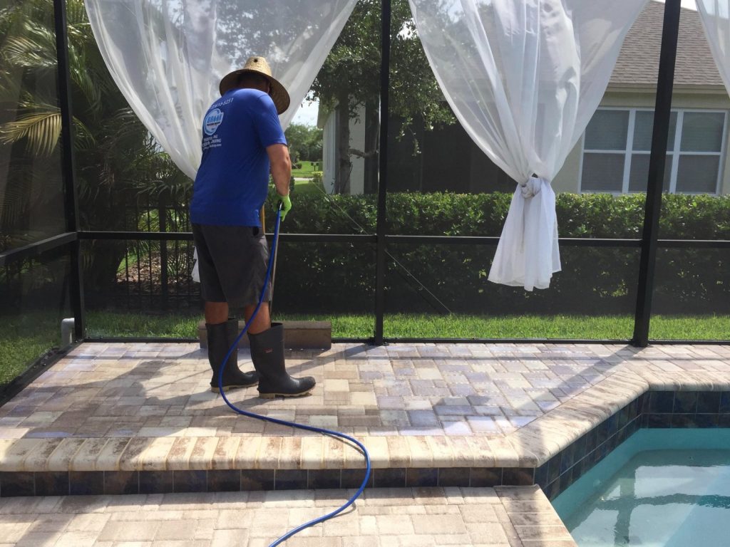 Paver sealing staff seals the poolside surface