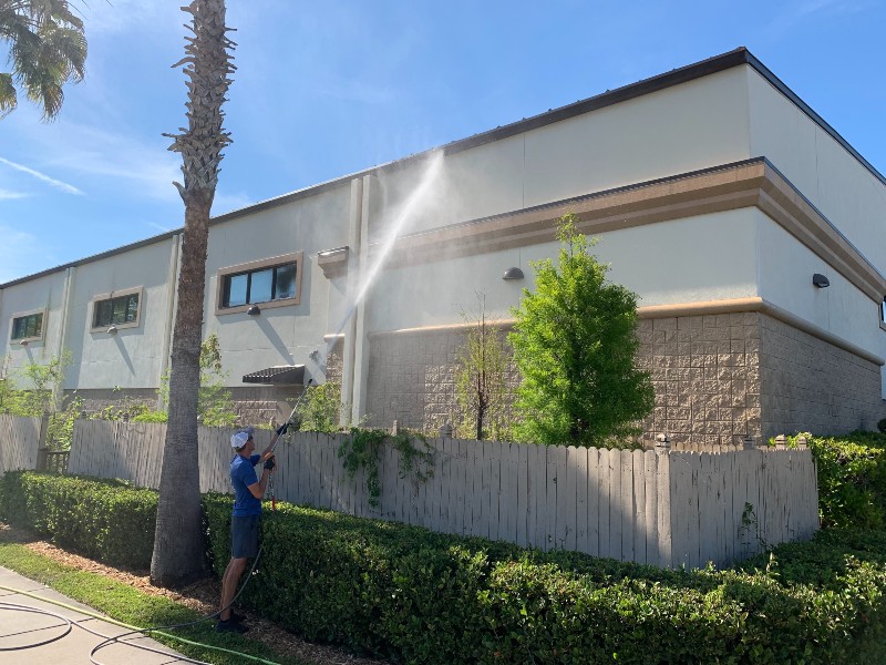 Exterior cleaning personnel uses super high-pressure washing tool to clean rain gutter