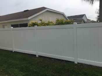 Newly cleaned white wooden fence through pressure washing